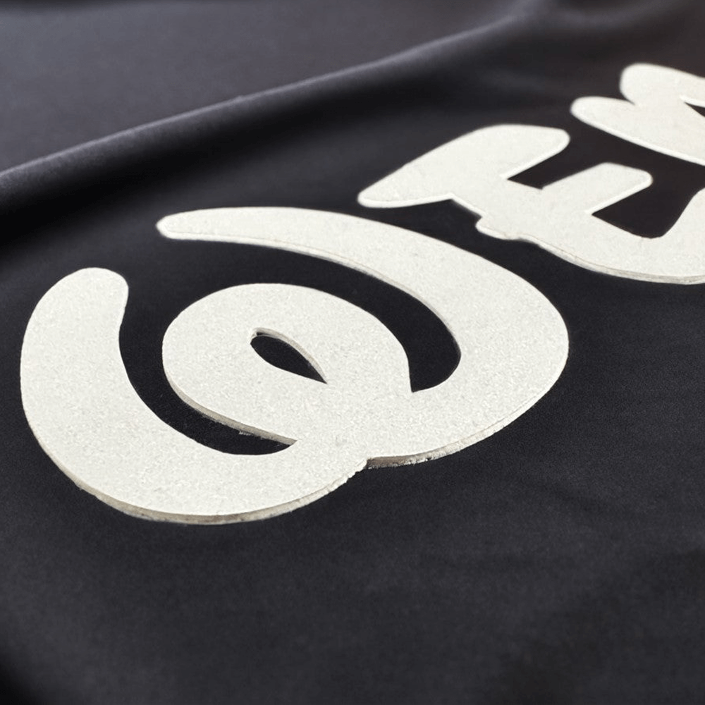 Close-up example of raised white heat transfer on black fabric